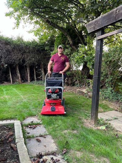 Tom with a lawn mower cutting grass